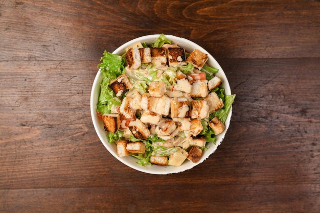 Salada de carne e legumes saudável fresca na mesa de madeira
