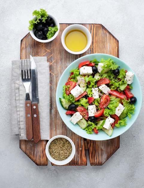 Foto grátis salada de cima com queijo feta na tábua de cortar com azeitonas e ervas