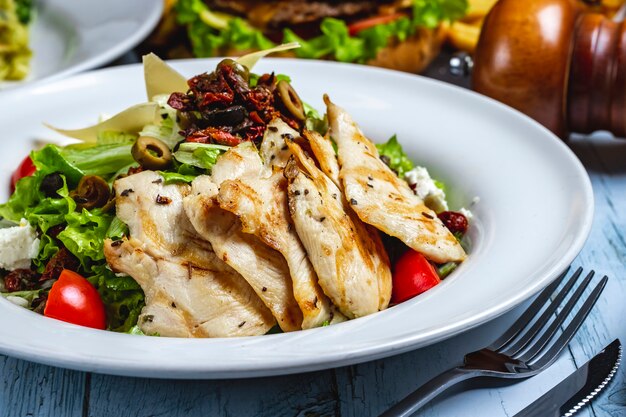 Salada de frango grelhado com alface tomate queijo branco azeitonas especiarias lado viewjpg