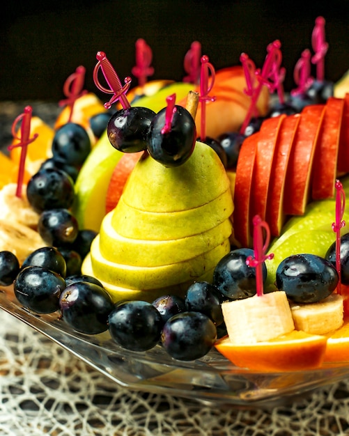 Foto grátis salada de frutas com maçãs, laranjas, bananas, uvas e peras