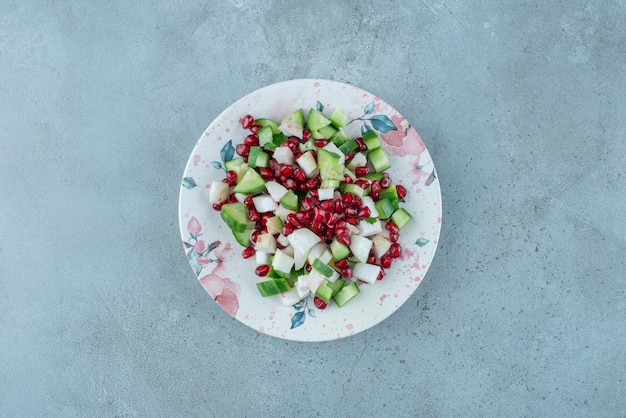 Salada de frutas e vegetais picados em uma travessa.