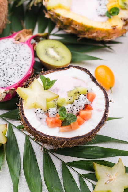 Foto grátis salada de frutas no prato de coco e folhas