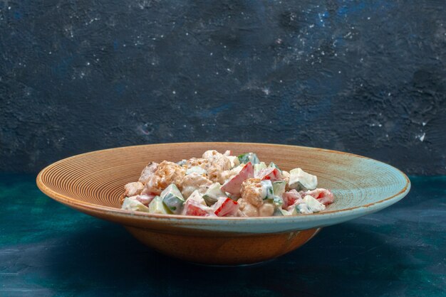 Salada de legumes à base de mayyon dentro de um prato marrom escuro