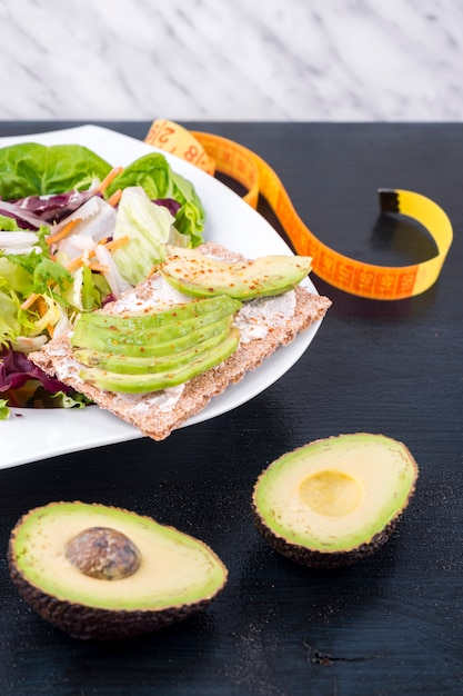 Salada de legumes com abacate no pão torrado na mesa