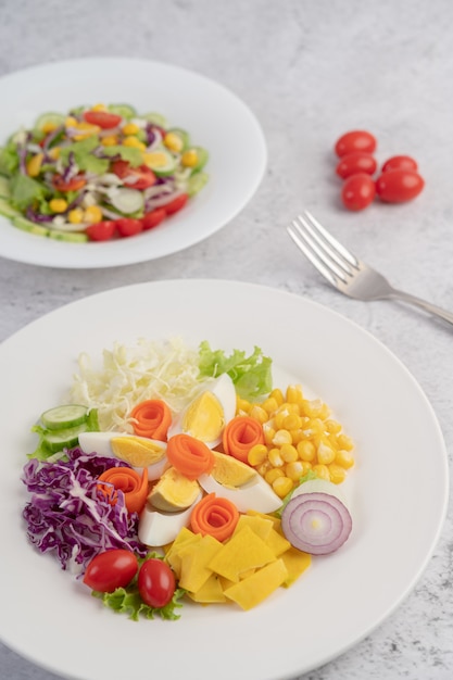 Salada de legumes com ovos cozidos em um prato branco.
