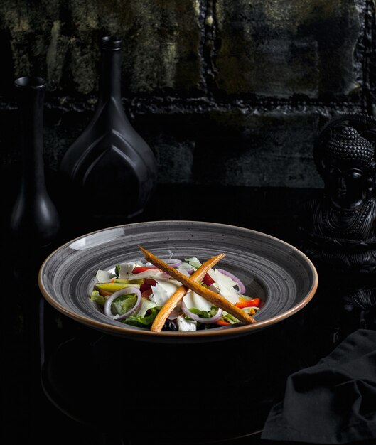 Salada de legumes contendo ingredientes misturados em um prato de cerâmica azul