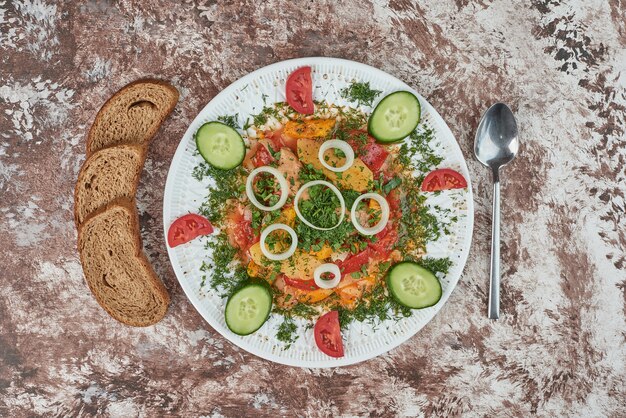 Salada de legumes em travessa de cerâmica branca com comidas coloridas