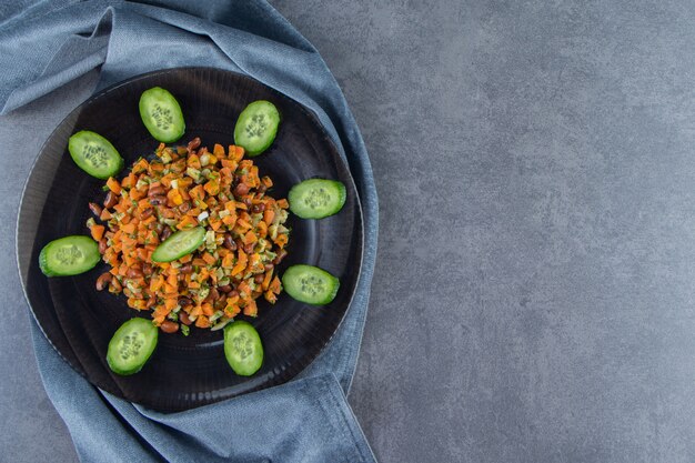 Salada de legumes em um prato sobre uma toalha na superfície de mármore