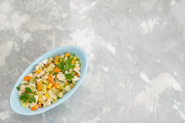 Salada de legumes fresca vista de cima com fatias de frango dentro de um prato azul na mesa de luz comida vegetal refeição jantar carne