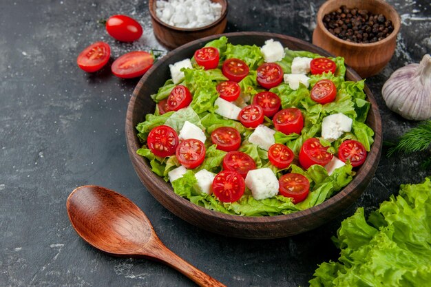 Salada de legumes vista frontal com tomates de queijo fatiados e temperos em fundo cinza comida refeição almoço saúde cor dieta