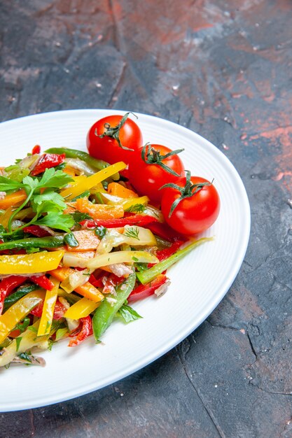 Salada de legumes vista inferior em prato oval em superfície escura