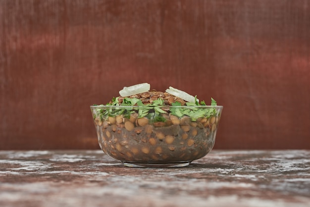 Foto grátis salada de lentilha em um copo de vidro com ervas.