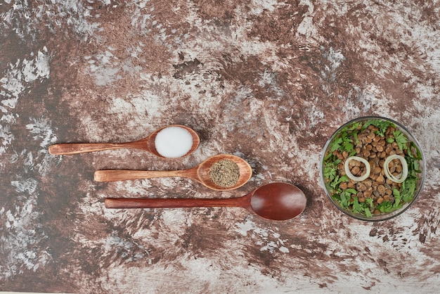 Salada de lentilha verde com ervas e cebola em um copo de vidro