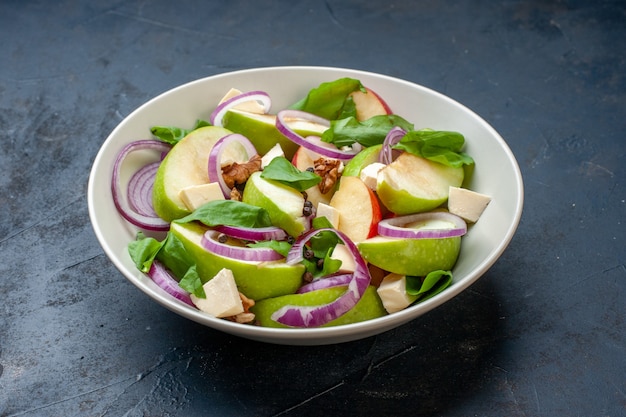 Salada de maçã fresca com vista inferior em uma tigela na mesa azul escura