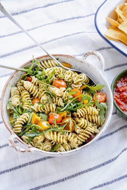 Salada de macarrão Rotini com rúcula e tomate cereja, prato saudável de verão