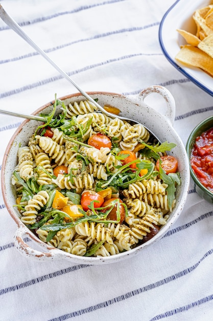 Salada de macarrão Rotini com rúcula e tomate cereja, prato saudável de verão