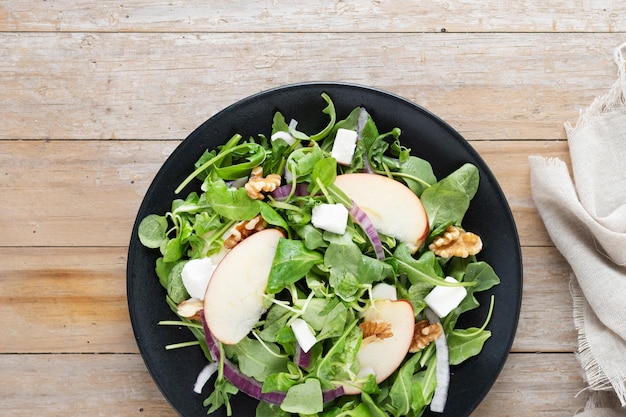 Foto grátis salada de outono com maçãs e nozes em mesa de madeira