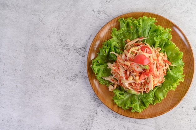 Salada de papaia tailandesa em uma placa de madeira