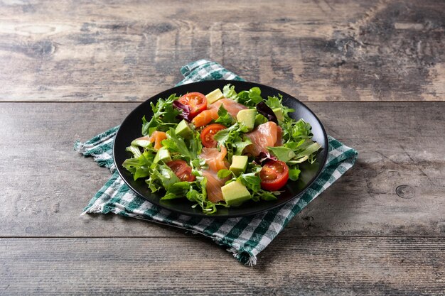 Salada de salmão e abacate em mesa de madeira rústica