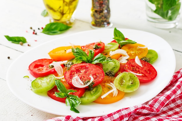 Salada de tomate colorido com pesto de cebola e manjericão.