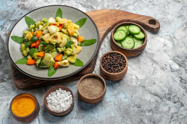 Salada de tomate verde vista inferior em prato oval na tábua de corte no escuro