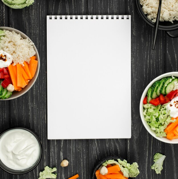 Salada de vista superior com cuscuz e caderno em branco