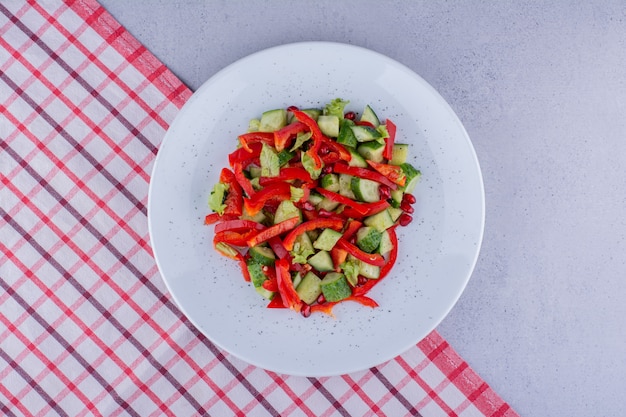 Salada deliciosa de pepino, pimenta e alface em uma toalha de mesa com fundo de mármore. foto de alta qualidade