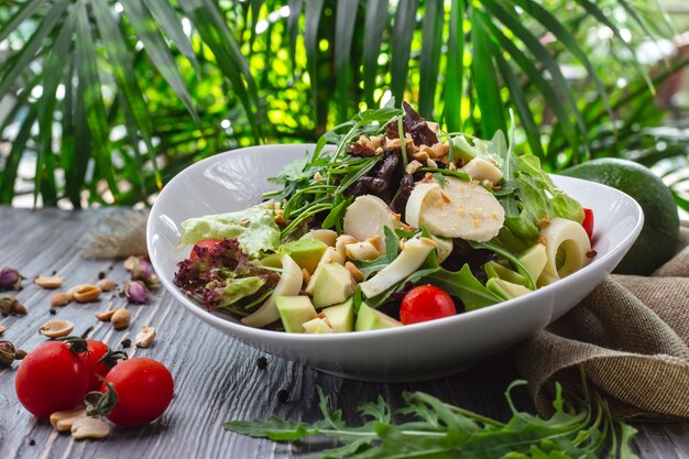 Salada fresca de vista frontal com rúcula abacate e tomate