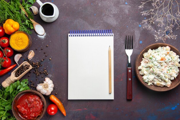 Salada maionese com verduras e legumes frescos em espaço escuro