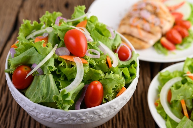 Salada na tigela na mesa de madeira.