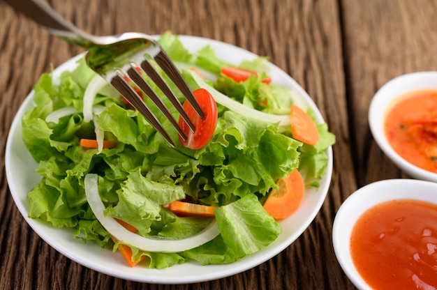 Salada no prato com tomate no garfo no espeto.