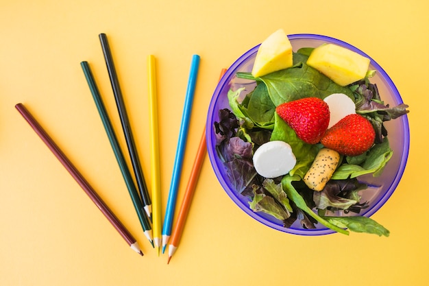 Foto grátis salada perto de lápis de cor