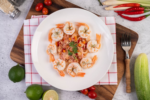 Salada picante com camarão em um prato branco. Comida tailandesa.