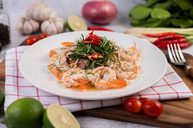 Salada picante com camarão em um prato branco. Comida tailandesa.