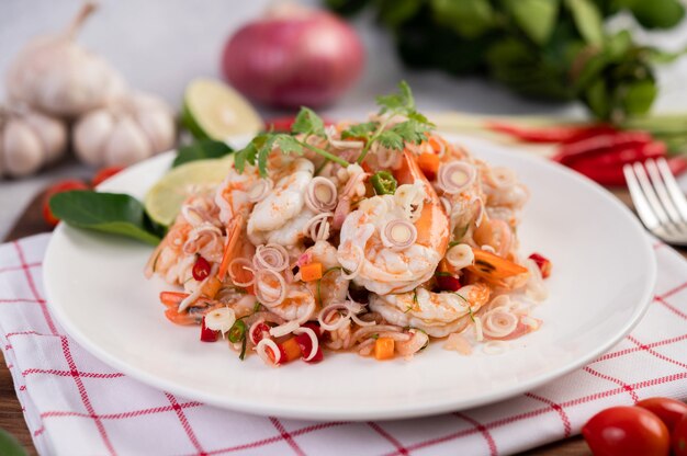 Salada picante com camarão em um prato branco. Comida tailandesa.