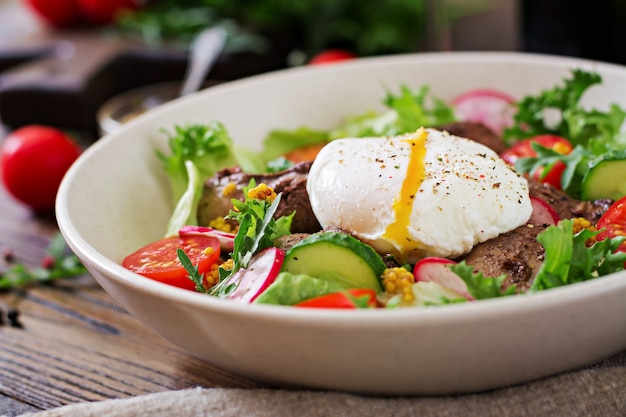 Salada quente de fígado de galinha, rabanete, pepino, tomate e ovo escalfado. comida saudável. menu dietético