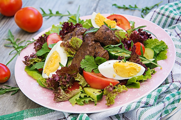 Salada quente de fígado de galinha, tomate, pepino e ovos. Jantar saudável. Menu dietético