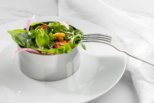 Salada saudável de ângulo alto em formato redondo de metal