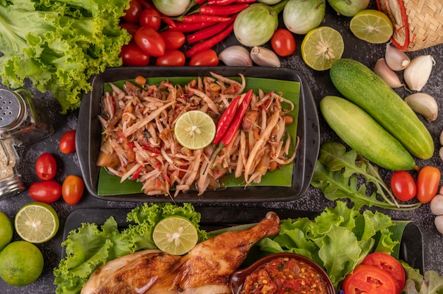 Salada tailandesa de papaia em uma placa preta.