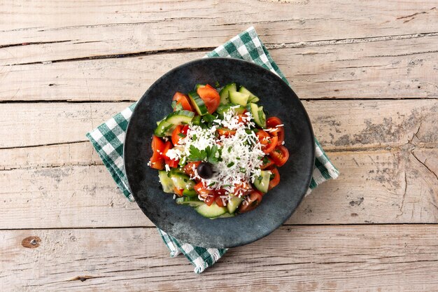 Salada tradicional búlgara shopska com tomate e queijo sirene búlgaro na mesa de madeira