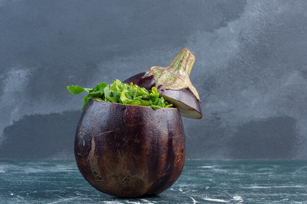 Salada verde em berinjela roxa esculpida.