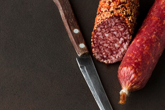 Salame de close-up com faca na mesa