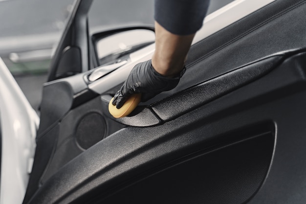 Salão de homem polonês de carro em uma garagem