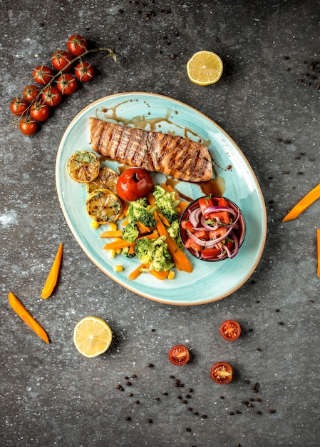 Salmão frito com legumes na mesa