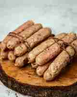 Foto grátis salsichas amarradas na mesa de madeira