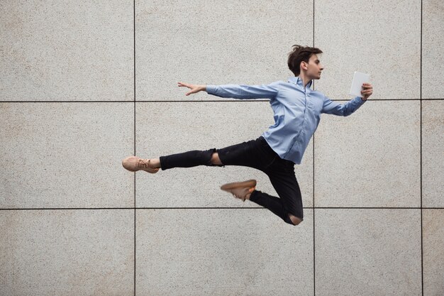 Salto jovem buinessman na frente de edifícios, em fuga no salto alto