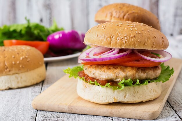 Sanduíche com hambúrguer de frango, tomate, cebola roxa e alface