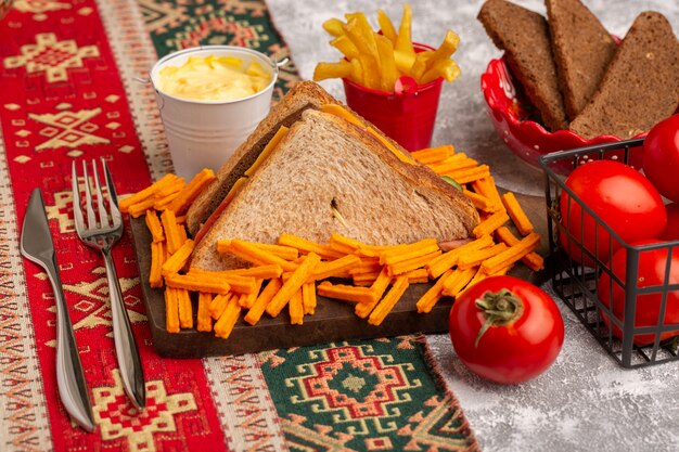 Sanduíche de torrada saborosa com queijo e presunto com batata frita e tomate com creme de leite.