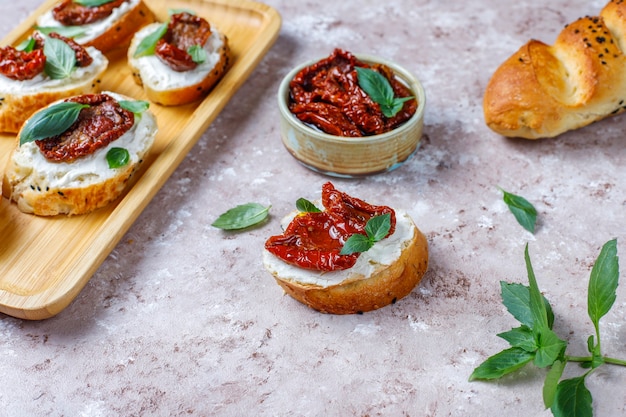 Foto grátis sanduíches italianos - bruschetta com queijo, tomate seco e manjericão.