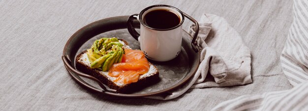 Sanduíches matinais com salmão e abacate na cama